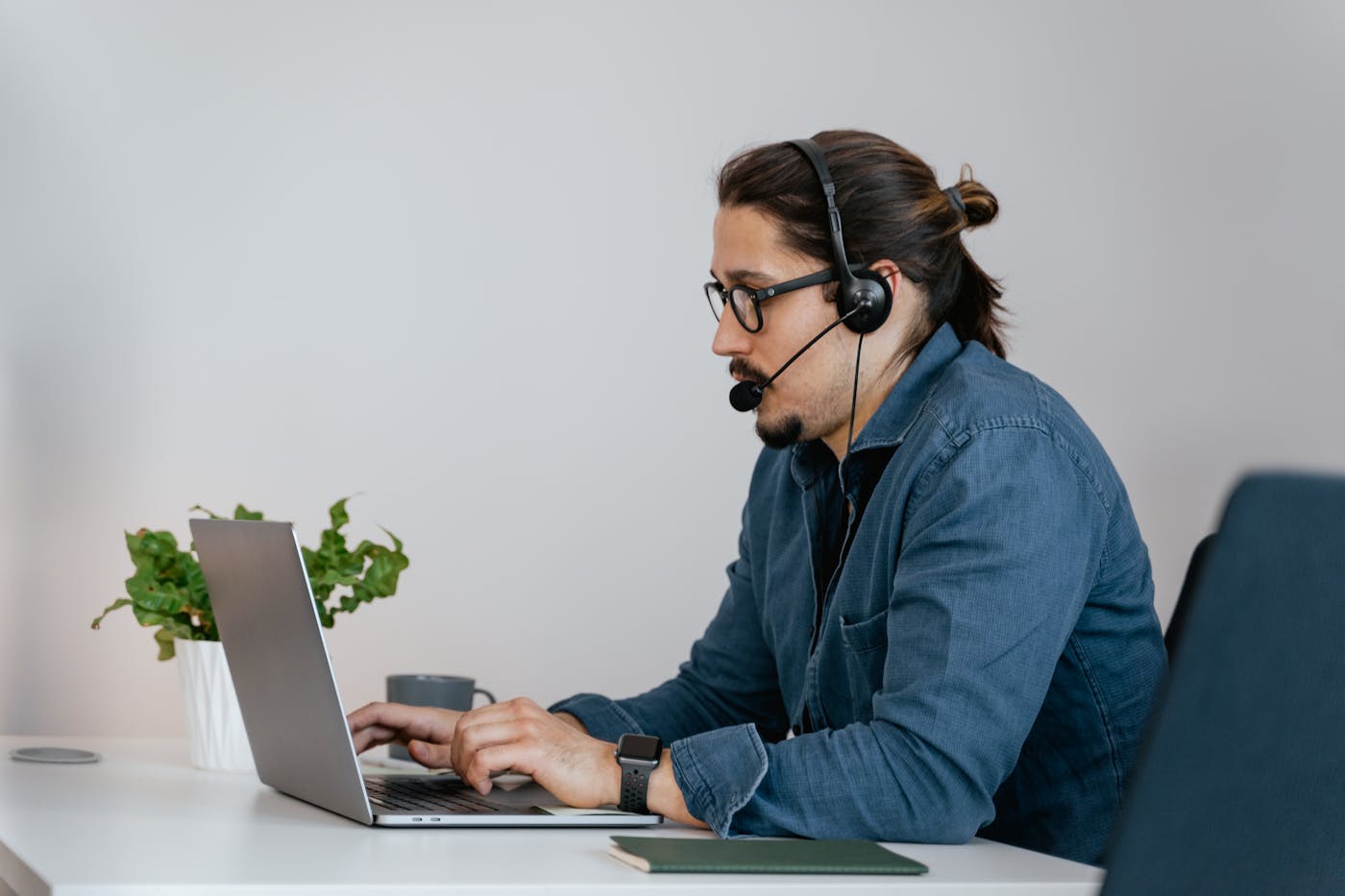 Support professional working at a laptop with a headset